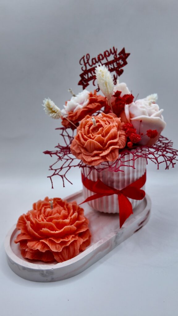 Czerwony flowerbox w gipsowej doniczce wraz z dużą piwonią na podstawce